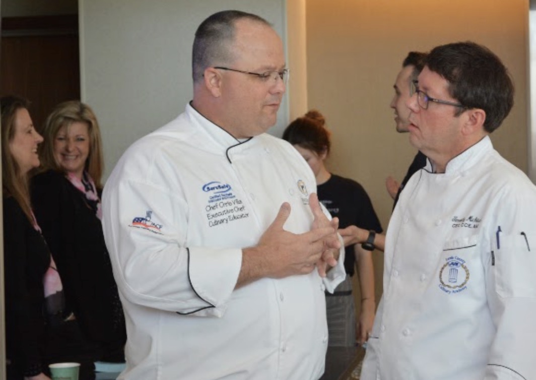 Chef Chris 'Bub' Villa speaking with fellow chef at culinary event